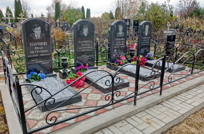 Место захоронения с четырьмя одинаковыми чёрными памятниками